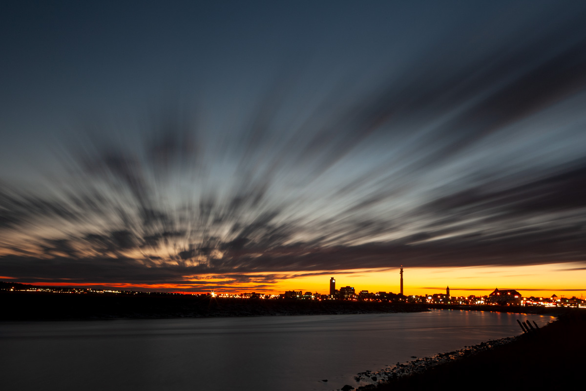 A long exposure photograph of the sunset over the Petitcodiac River and the City of Moncton skyline.